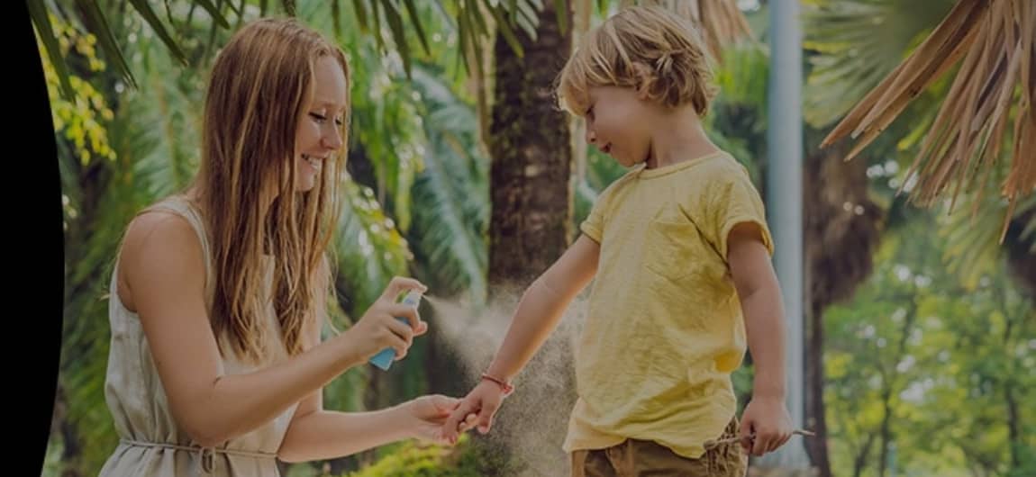 image of a mother applying insect repellant to a child
